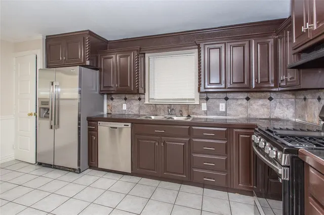 a kitchen with granite countertop a refrigerator and a stove top oven