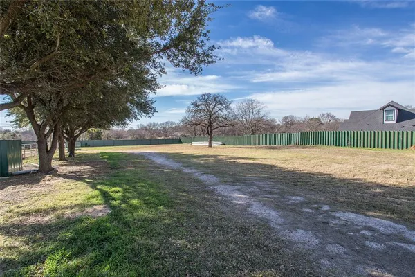 a dirt road with an entrance to house