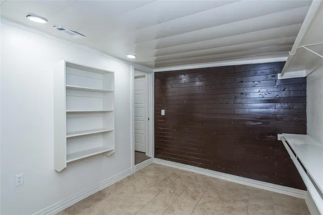 an empty room with chandelier fan