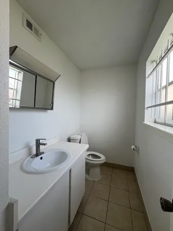 a bathroom with a sink toilet and mirror