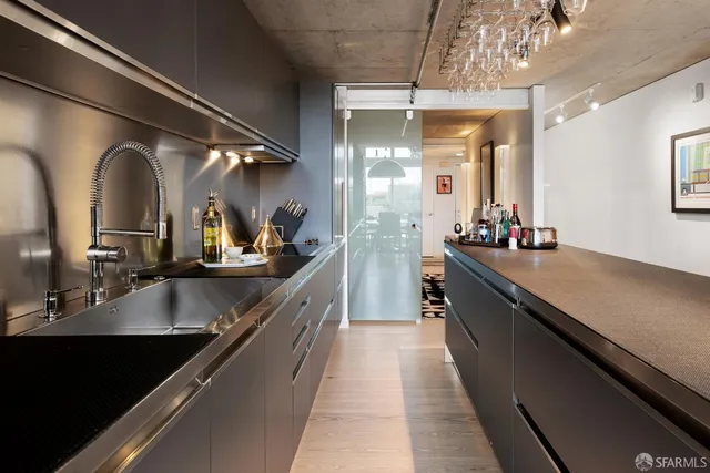 a large kitchen with a large counter top a sink and cabinets