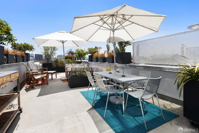 a view of a patio with a table and chairs under an umbrella