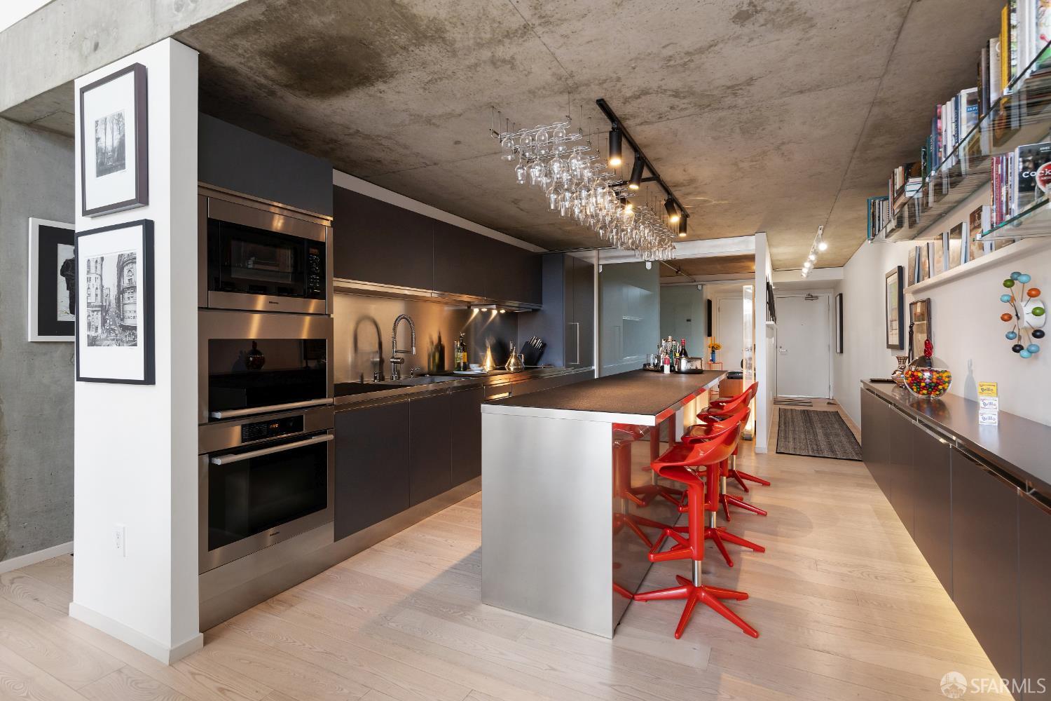 855 Folsom Street, Unit 519 San Francisco, CA 94107 - Photo 3 of 25 a kitchen with stainless steel appliances kitchen island granite countertop a refrigerator a stove a microwave oven with a dining table and chairs