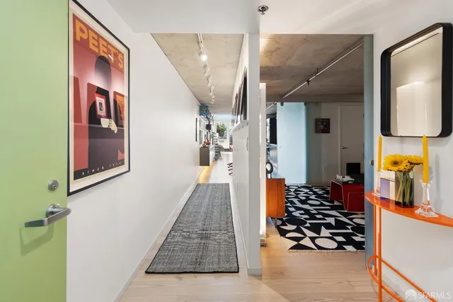 a hallway with painting on the wall and a large mirror