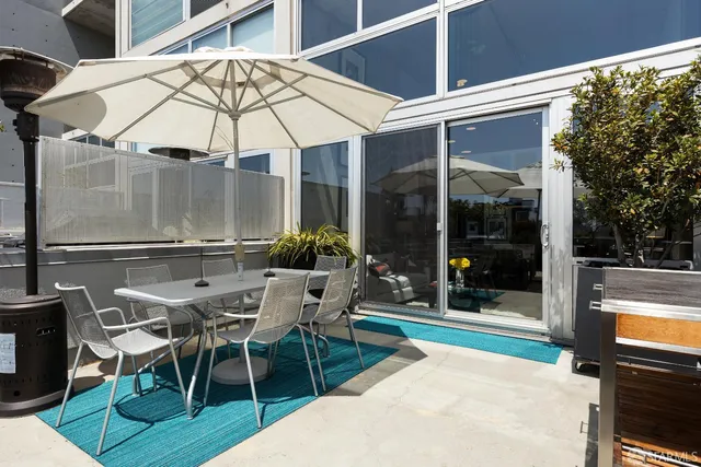 a view of a patio with table and chairs under an umbrella
