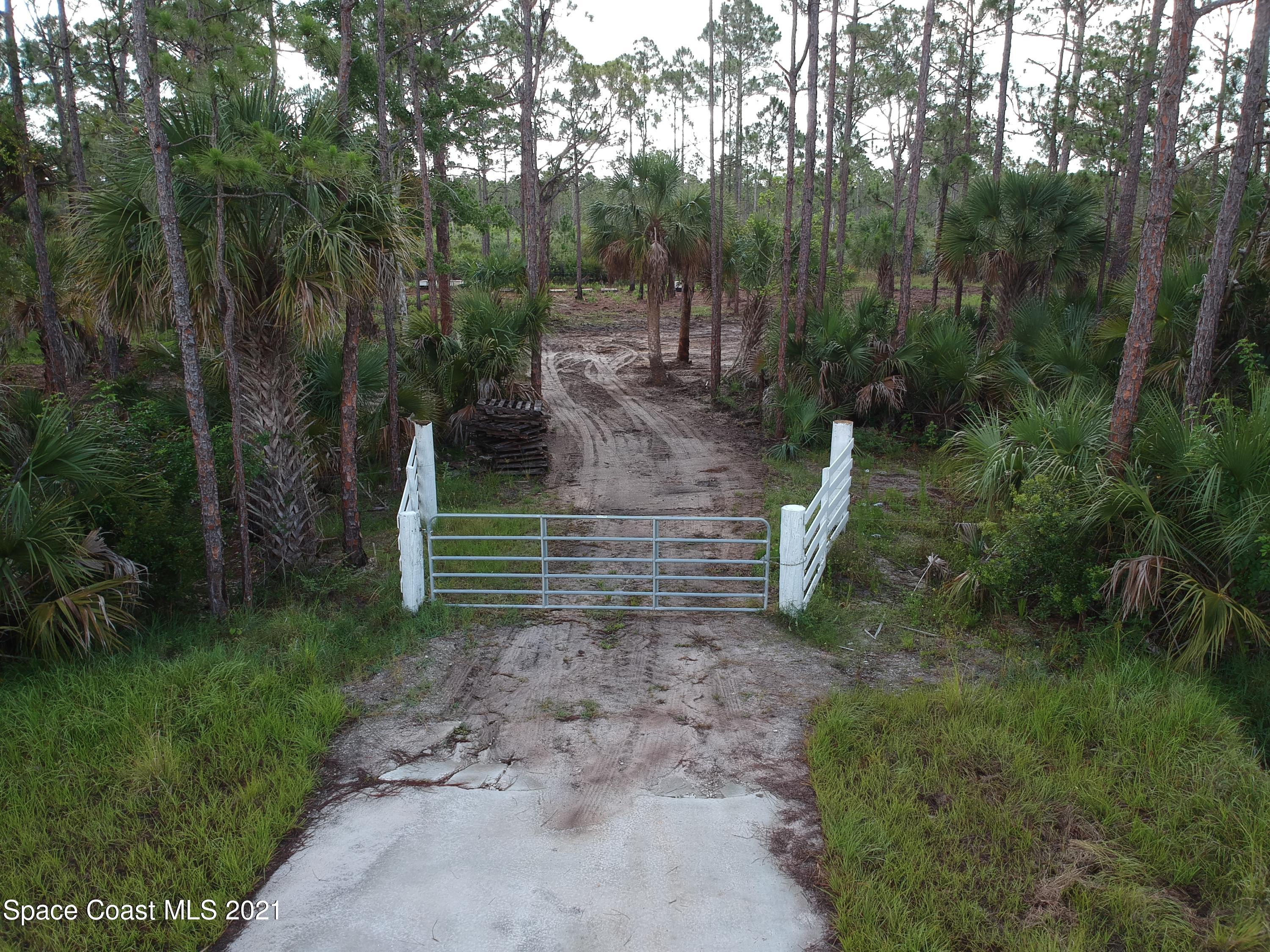 4885 Corey Road Grant Valkaria, FL 32950 - Photo 1 of 9 a view of a pathway of a yard