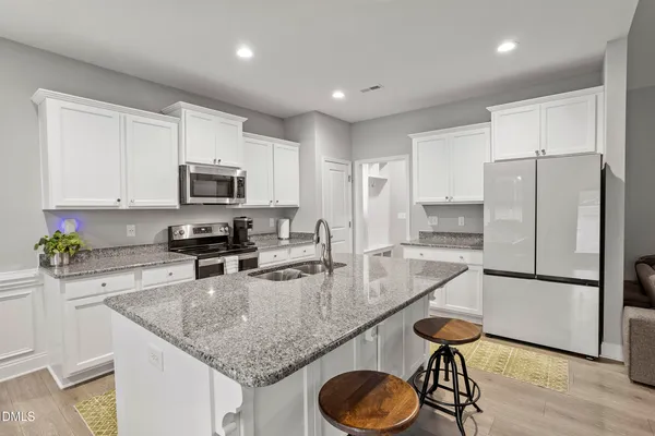a kitchen with sink refrigerator and microwave