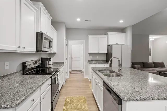 a kitchen with stainless steel appliances granite countertop a sink stove and cabinets