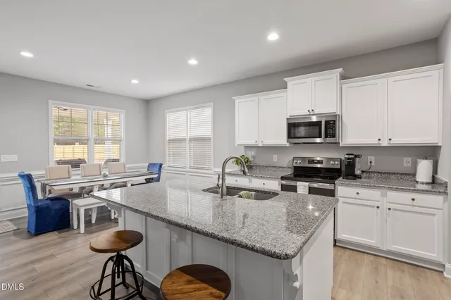 a kitchen with stainless steel appliances granite countertop a sink stove and microwave