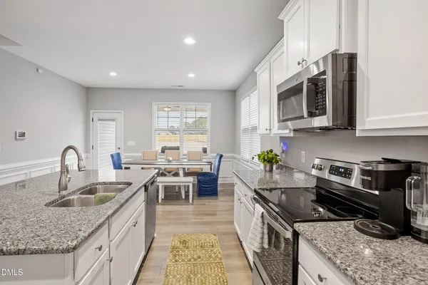 a kitchen with stainless steel appliances granite countertop a sink stove and cabinets