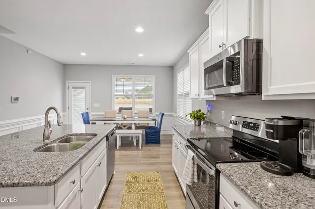 a kitchen with stainless steel appliances granite countertop a sink stove and cabinets