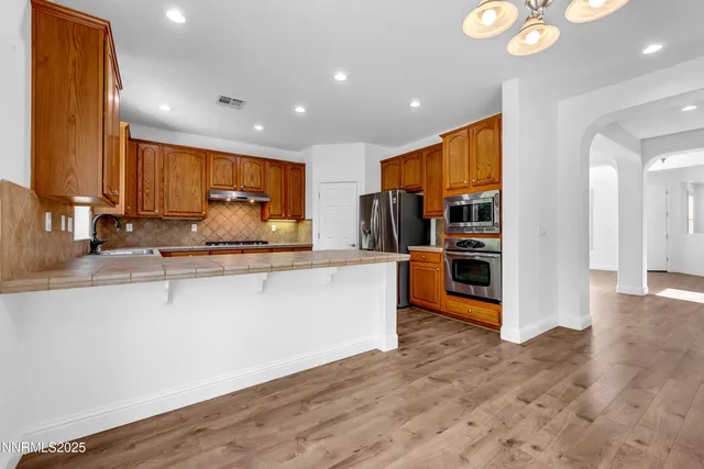 an empty room with chandelier fan and closet area
