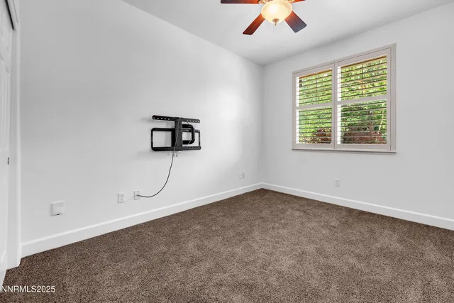a view of a livingroom with wooden floor and a ceiling fan