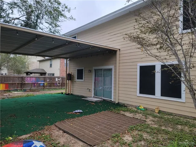 a view of a backyard with table and chairs under an umbrella