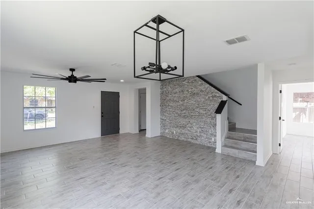 an empty room with stairs and windows