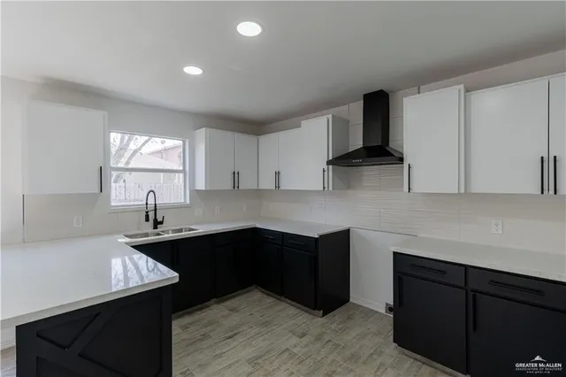 a kitchen with stainless steel appliances granite countertop a sink dishwasher a stove and white cabinets with wooden floor