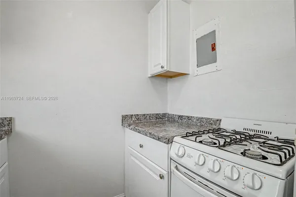 a white stove top oven sitting inside of a kitchen