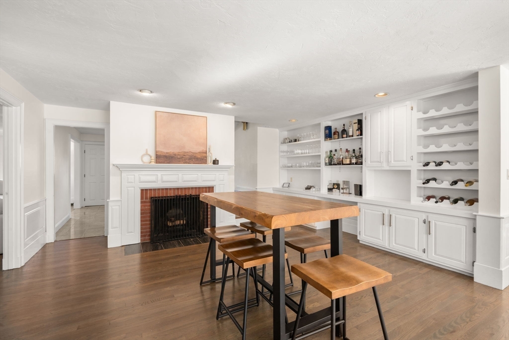 23 Bubbling Brook Road Walpole, MA 02081 - Photo 12 of 41 a kitchen with a table chairs and a fireplace