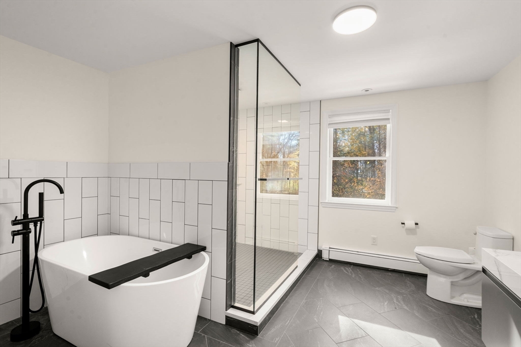 23 Bubbling Brook Road Walpole, MA 02081 - Photo 23 of 41 a spacious bathroom with a bathtub and toilet