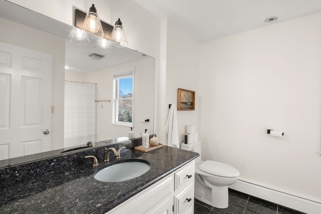 23 Bubbling Brook Road Walpole, MA 02081 - Photo 30 of 41 a bathroom with a granite countertop sink a mirror and a toilet