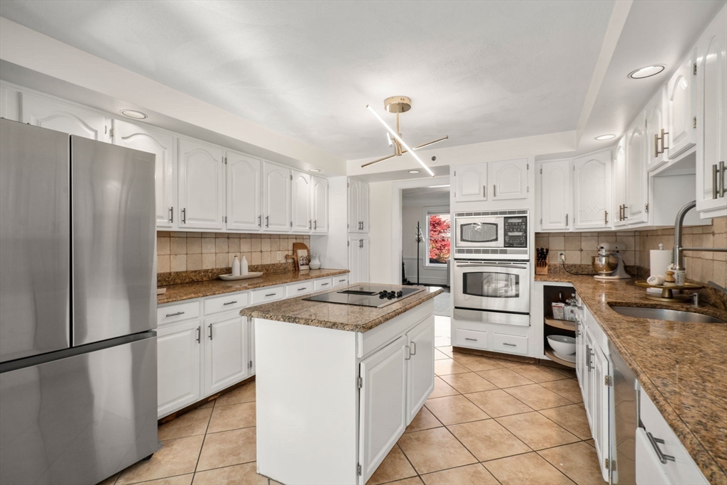 23 Bubbling Brook Road Walpole, MA 02081 - Photo 9 of 41 a kitchen with stainless steel appliances granite countertop a stove top oven a refrigerator a sink and dishwasher with white cabinets