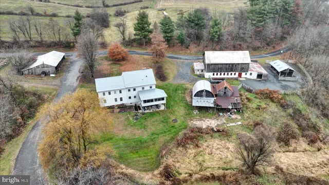a view of a white house with a big yard and large trees