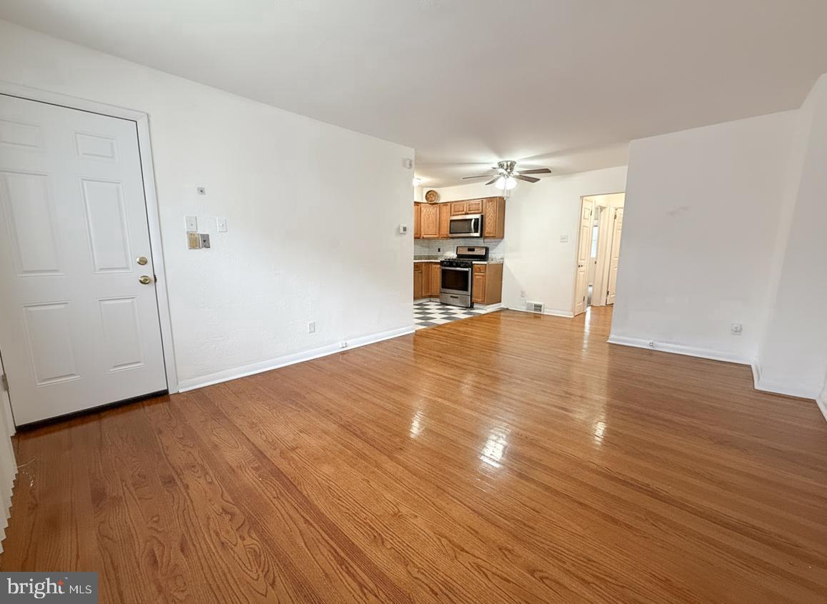 a view of empty room with wooden floor