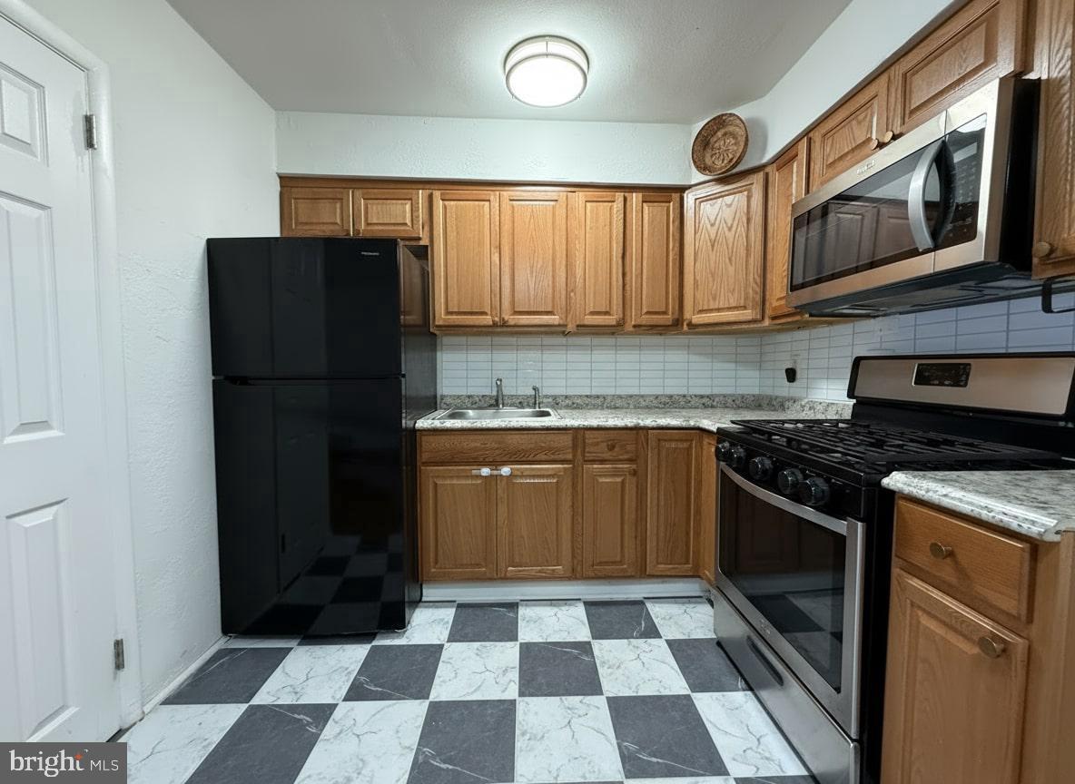 7332 Ruskin Road Philadelphia, PA 19151 - Photo 3 of 20 a kitchen with stainless steel appliances granite countertop a refrigerator and a stove