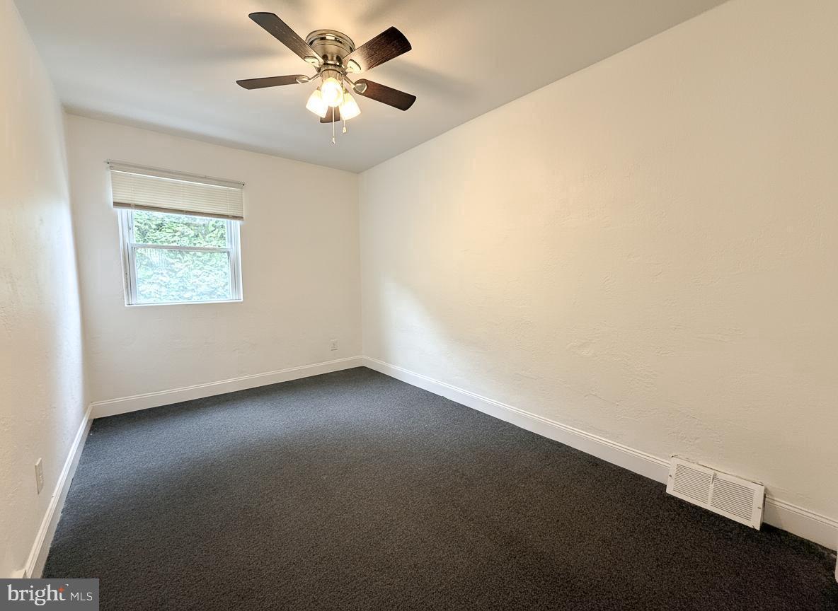 7332 Ruskin Road Philadelphia, PA 19151 - Photo 5 of 20 an empty room with a window and a fan