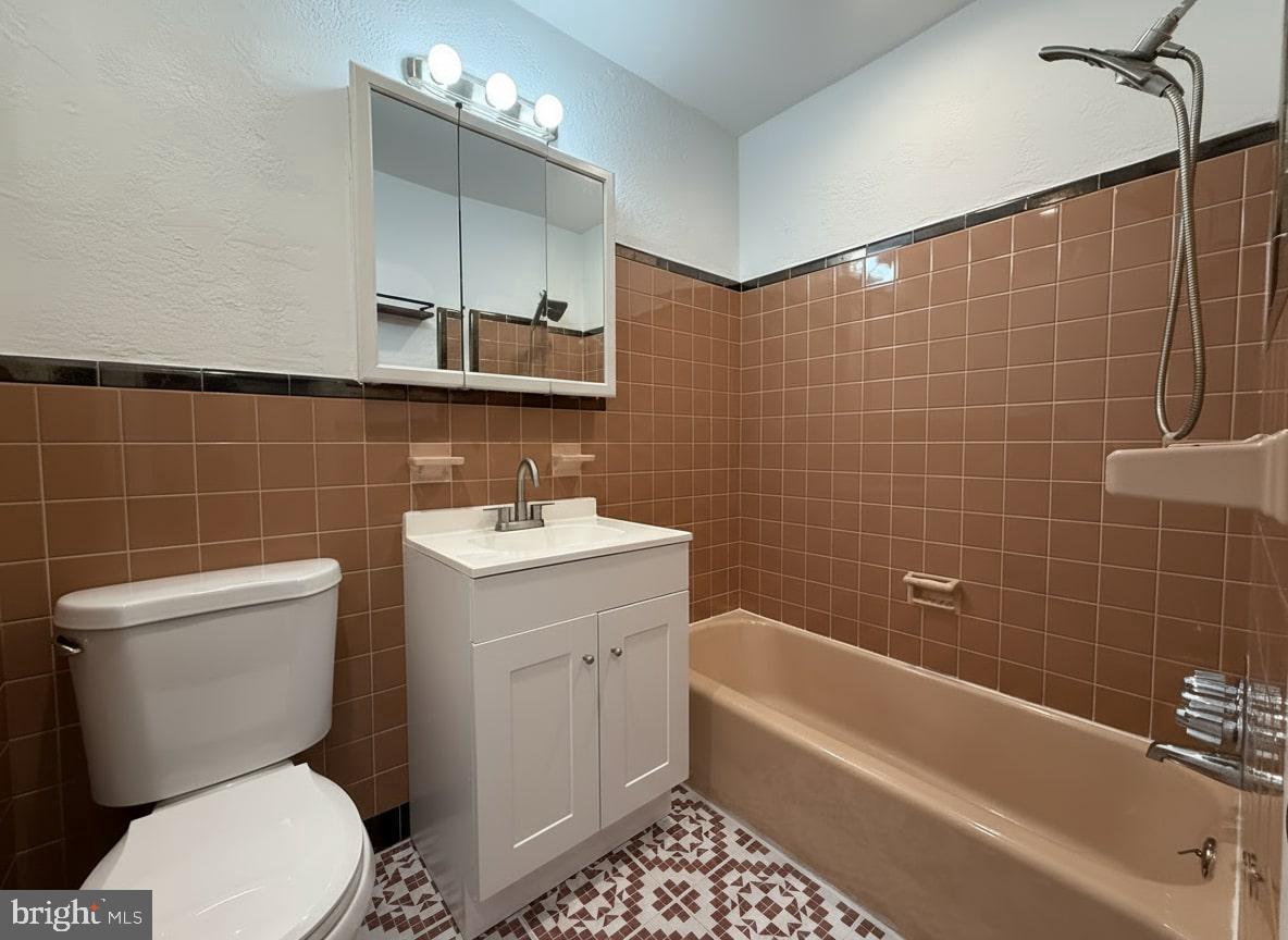 7332 Ruskin Road Philadelphia, PA 19151 - Photo 8 of 20 a bathroom with a toilet a sink a mirror a bathtub and shower