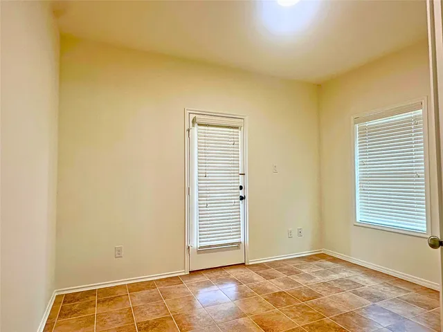 a view of an empty room with closet and a window