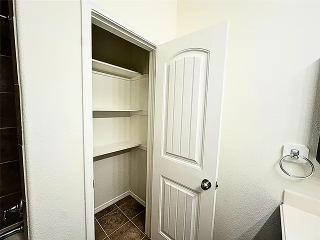 a bathroom with a walk in closet and wooden floor
