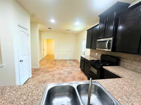 a kitchen with granite countertop stove top oven and sink