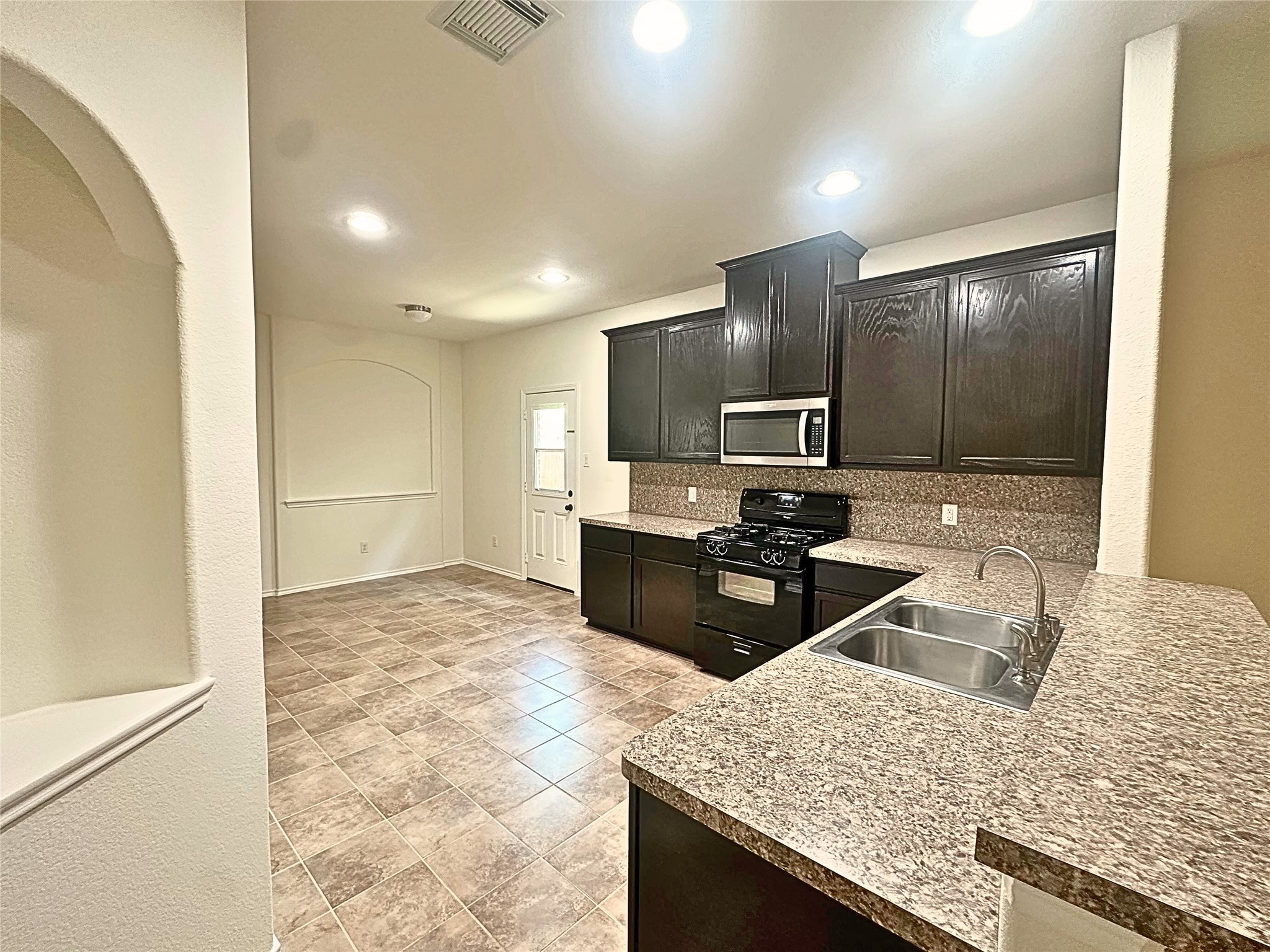 8218 Nagy Hill Street Spring, TX 77379 - Photo 5 of 30 a kitchen with kitchen island granite countertop a sink refrigerator and microwave