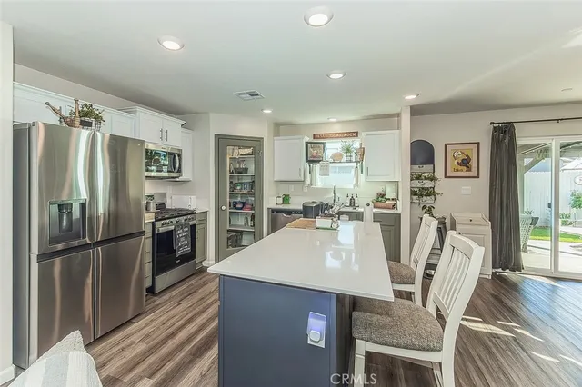a kitchen with stainless steel appliances a refrigerator a table and chairs