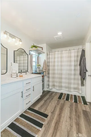 a spacious bathroom with a shower a sink and a mirror