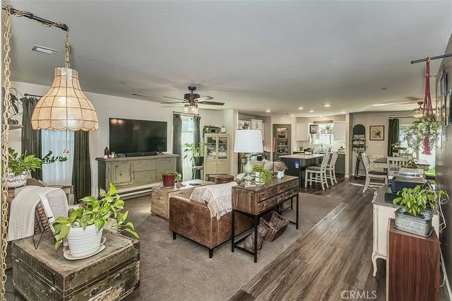 a living room with furniture a flat screen tv and a chandelier