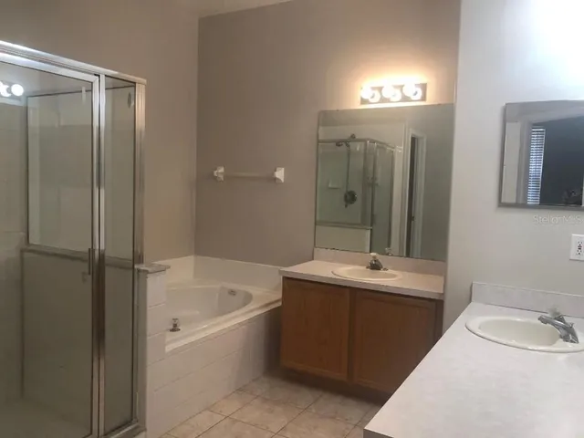 a bathroom with a tub sink and mirror