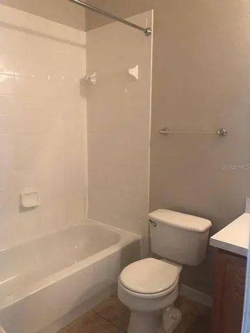 a white toilet sitting next to a bath tub and a shower
