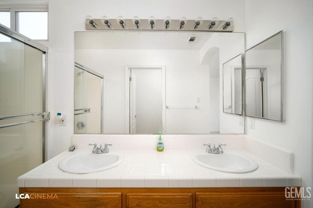 Undisclosed Address Bakersfield, CA 93312 - Photo 9 of 23 a bathroom with double vanity sinks and a mirror