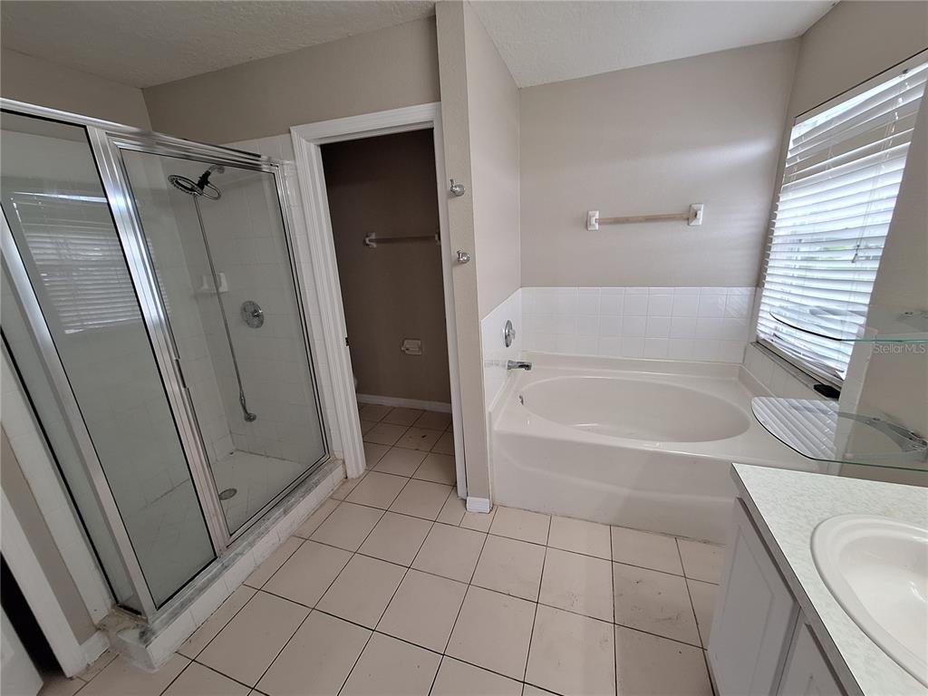 27854 Breakers Drive Zephyrhills, FL 33544 - Photo 11 of 16 a bathroom with a tub shower and vanity
