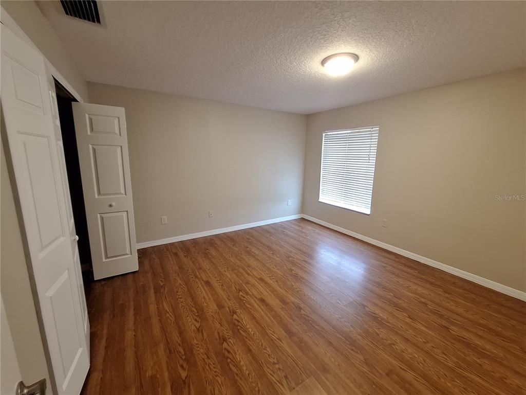 27854 Breakers Drive Zephyrhills, FL 33544 - Photo 14 of 16 an empty room with wooden floor and windows