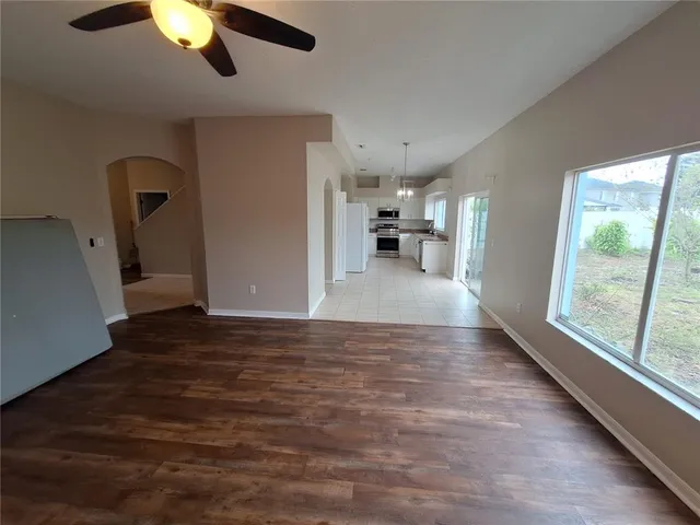 a view of a livingroom with furniture hardwood floor and windows