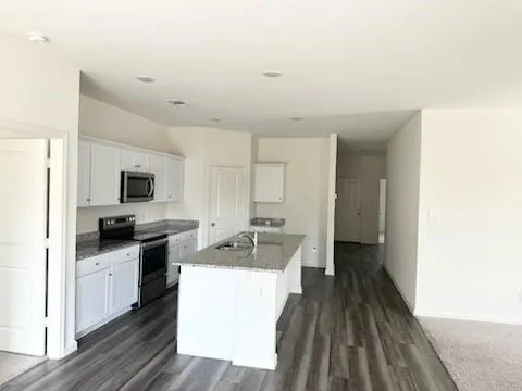 a kitchen with a sink a counter top space stainless steel appliances and cabinets