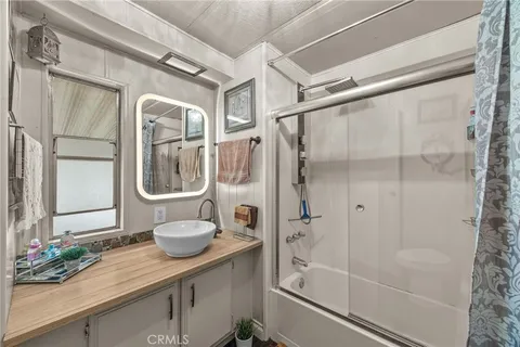 a bathroom with a granite countertop sink a mirror and a shower