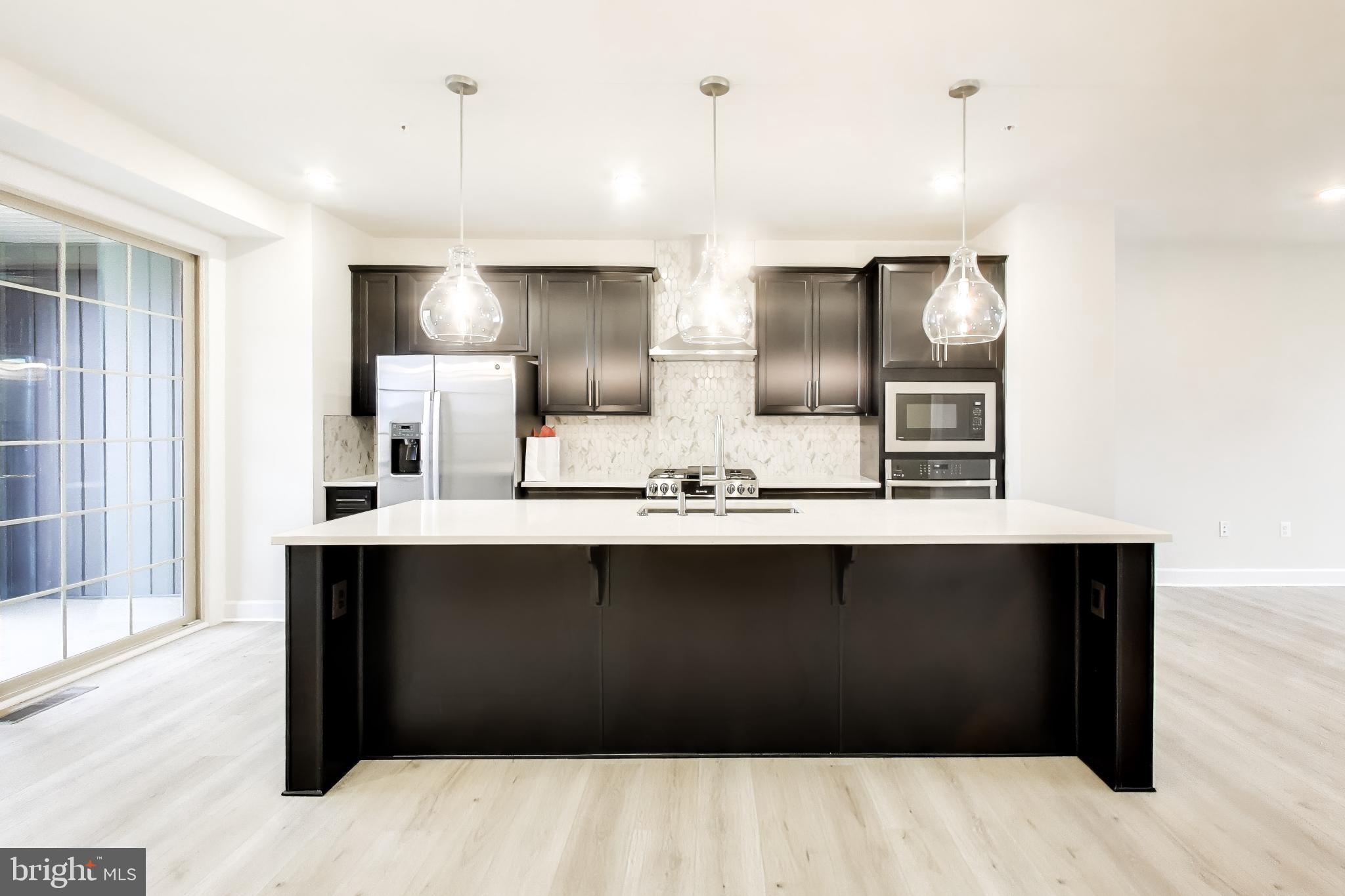 1774 Mill Branch Drive Laurel, MD 20708 - Photo 14 of 42 a kitchen with stainless steel appliances kitchen island sink and refrigerator