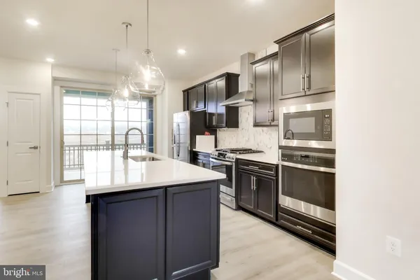 a kitchen with kitchen island granite countertop stainless steel appliances and sink