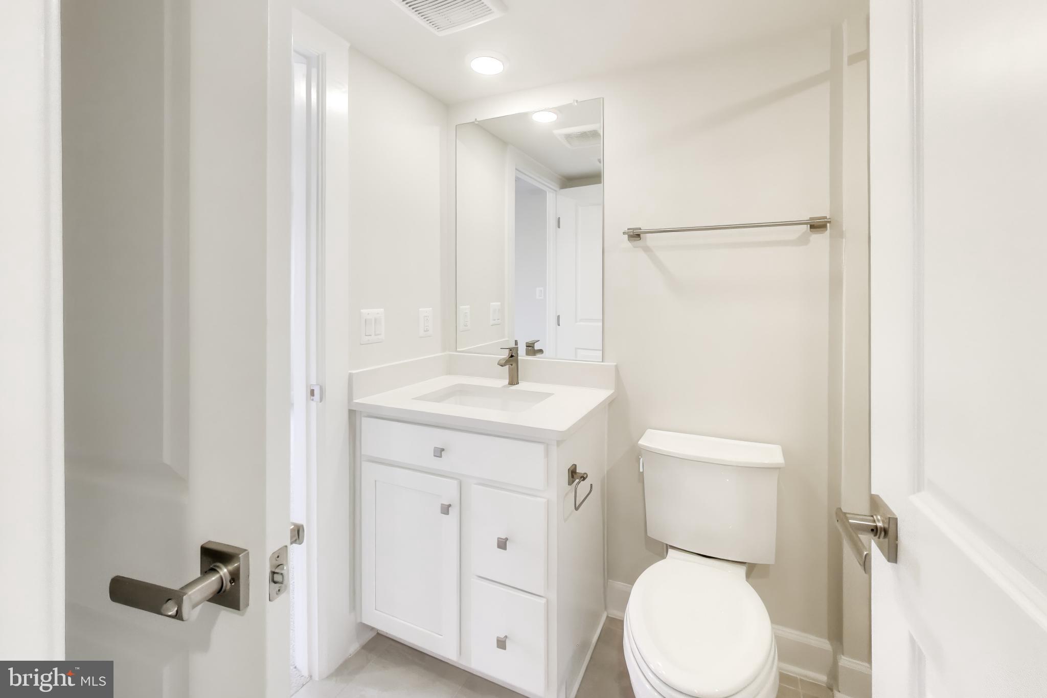 1774 Mill Branch Drive Laurel, MD 20708 - Photo 8 of 42 a bathroom with a toilet sink and a mirror