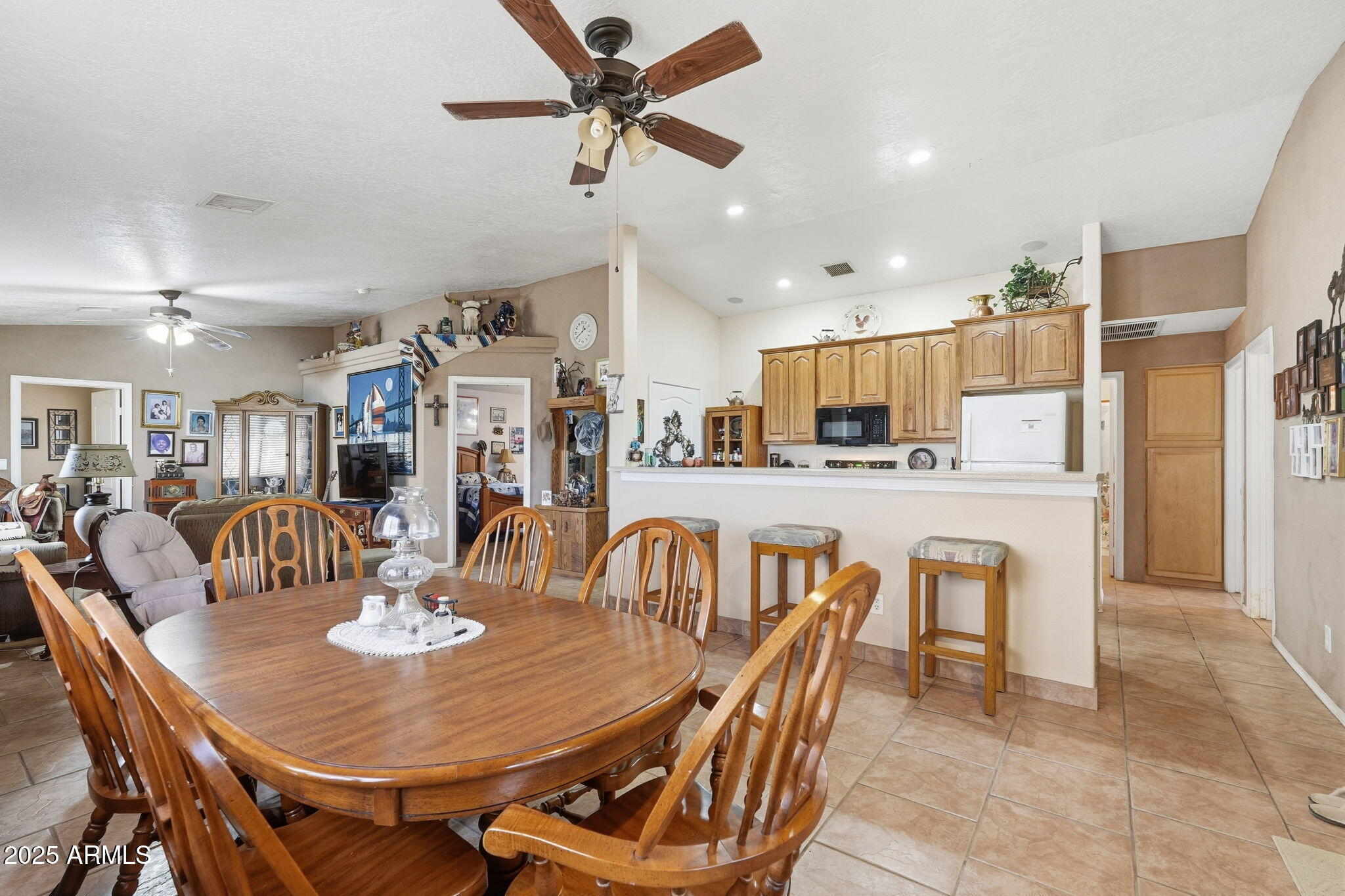 53607 West Moondust Road Maricopa, AZ 85139 - Photo 17 of 38 a dining room with stainless steel appliances kitchen island granite countertop a dining table and chairs