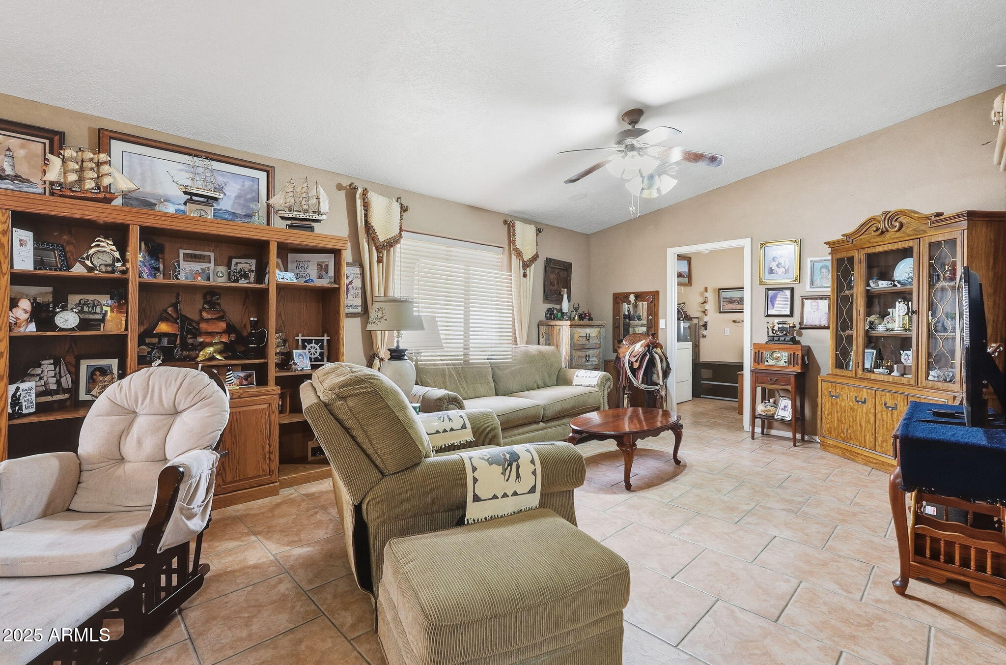53607 West Moondust Road Maricopa, AZ 85139 - Photo 5 of 38 a living room with furniture a bookshelf and a book shelf